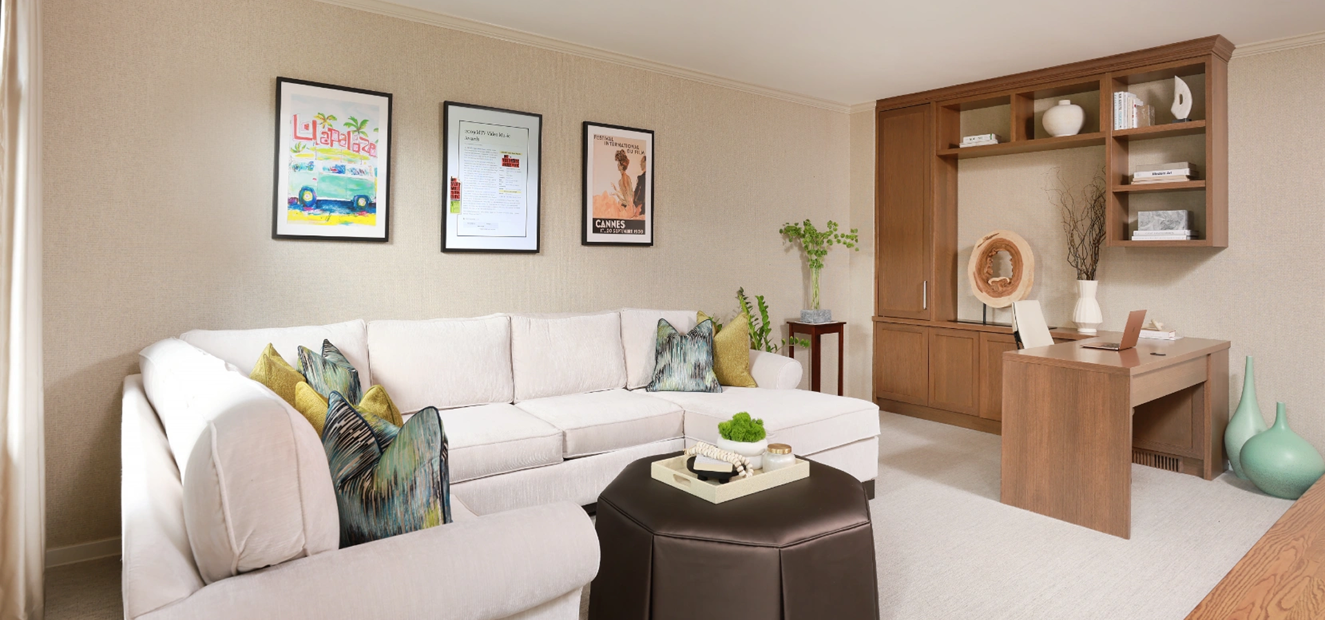 Living room with a sofa and cushions, a table with various objects on it, a plant in a pot